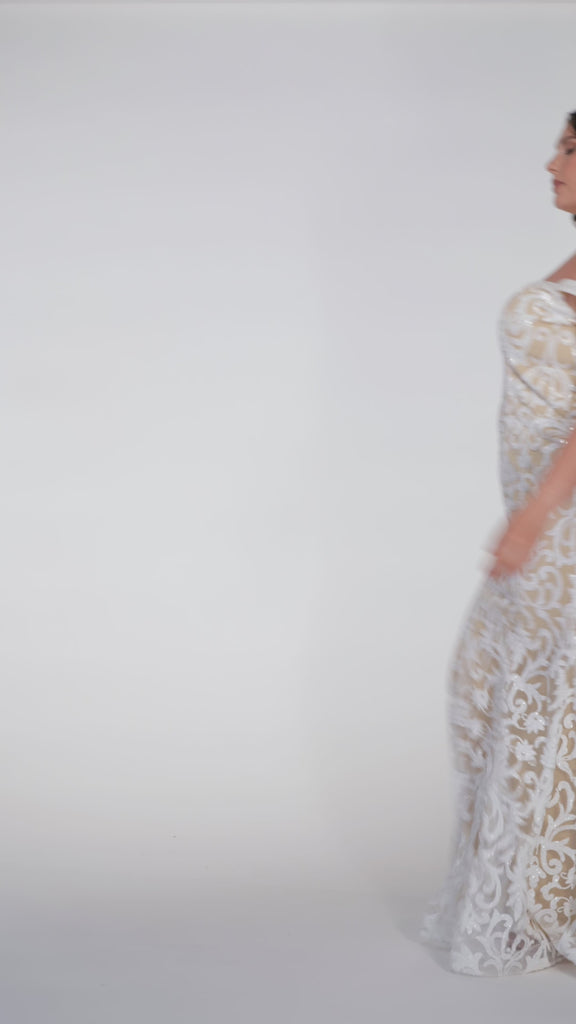 Plus-size woman wearing an off-the-shoulder nude and ivory sequin embroidered formal gown with sweetheart neckline, off-the-shoulder straps and fitted silhouette. CE2611 available from Sydney's Closet