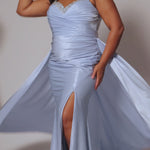 Plus Size satin fitted pleated formal dress with silver beaded straps and V-neckline detail. Pleated bodice, ruching on fitted skirt with slit. Attached overskirt included. Avialablie in fire red, magenta pink, onyx black, and sky blue in plus sizes 14-28. Style TE2513 by Tease Prom. 