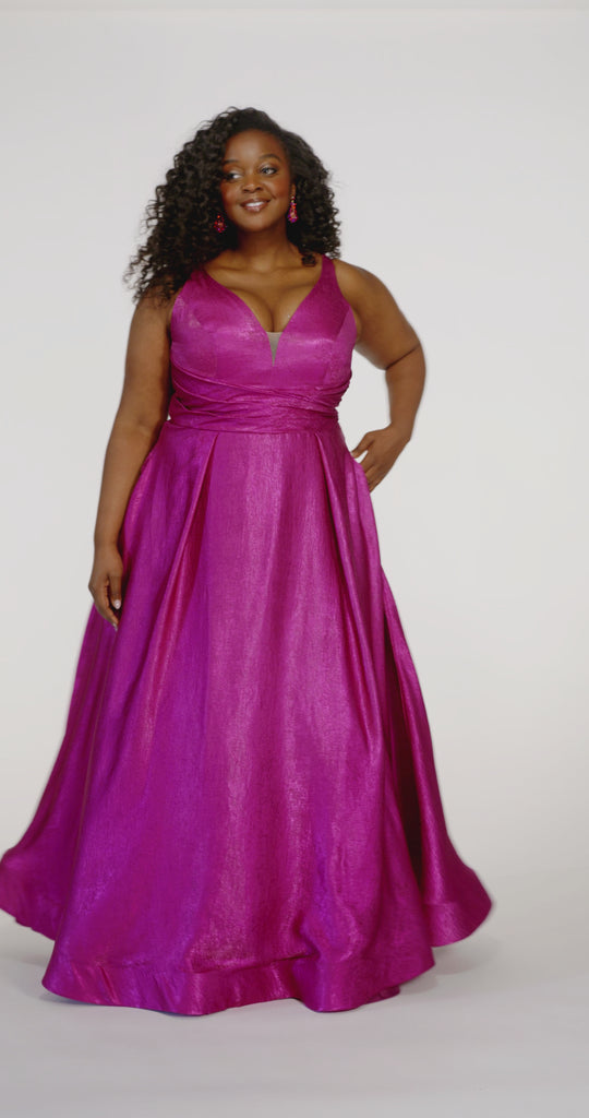 Sydney's Closet Style SC7453 in Magenta Pink

Plus Size A-line prom dress in metallic shimmer knit fabric, V-neckline with nude mesh insert, bra-friendly straps, pleated bodice, natural waisltine, A-line skirt with box pleats, pockets and a horsehair hem.