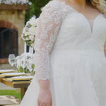 Plus-size bride modeling the MB2604 wedding gown by Michelle Bridal, featuring a structured bodice and elegant flowing silhouette designed for curvy brides.