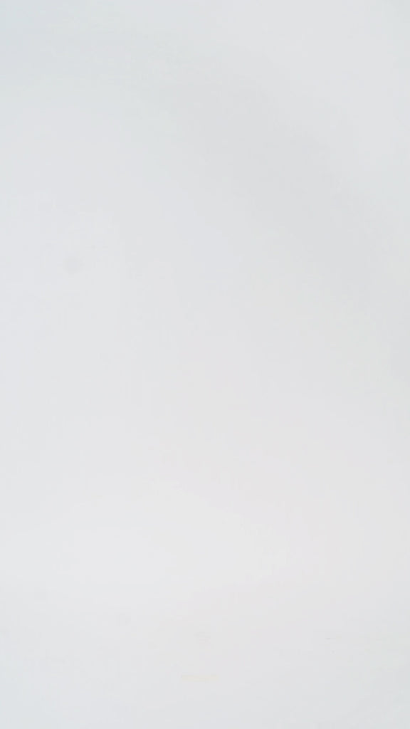 Woman models a strapless tea-length dress with a brown and black animal print and folded neckline detail, turning to show the back before walking off screen.