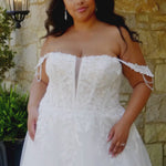 Plus-size bride wearing the Michelle Bridal MB2611 Della wedding gown in ivory tulle and organza with floral appliqués and beaded crystal details, featuring a strapless modified sweetheart silhouette and flowing skirt.