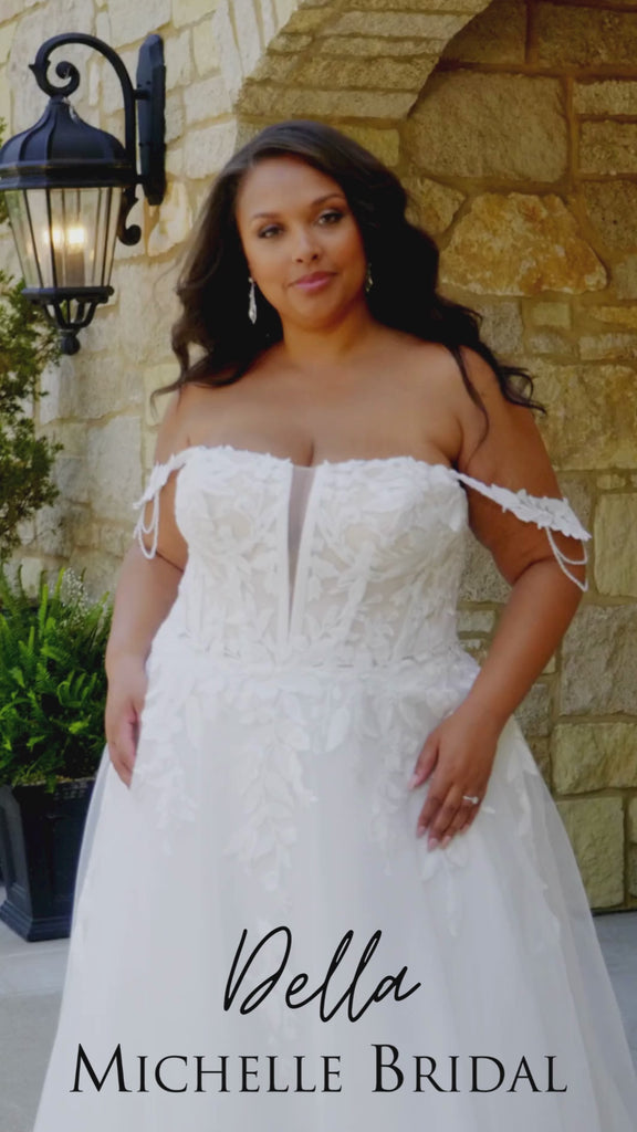 Plus-size bride wearing the Michelle Bridal MB2611 Della wedding gown in ivory tulle and organza with floral appliqués and beaded crystal details, featuring a strapless modified sweetheart silhouette and flowing skirt.