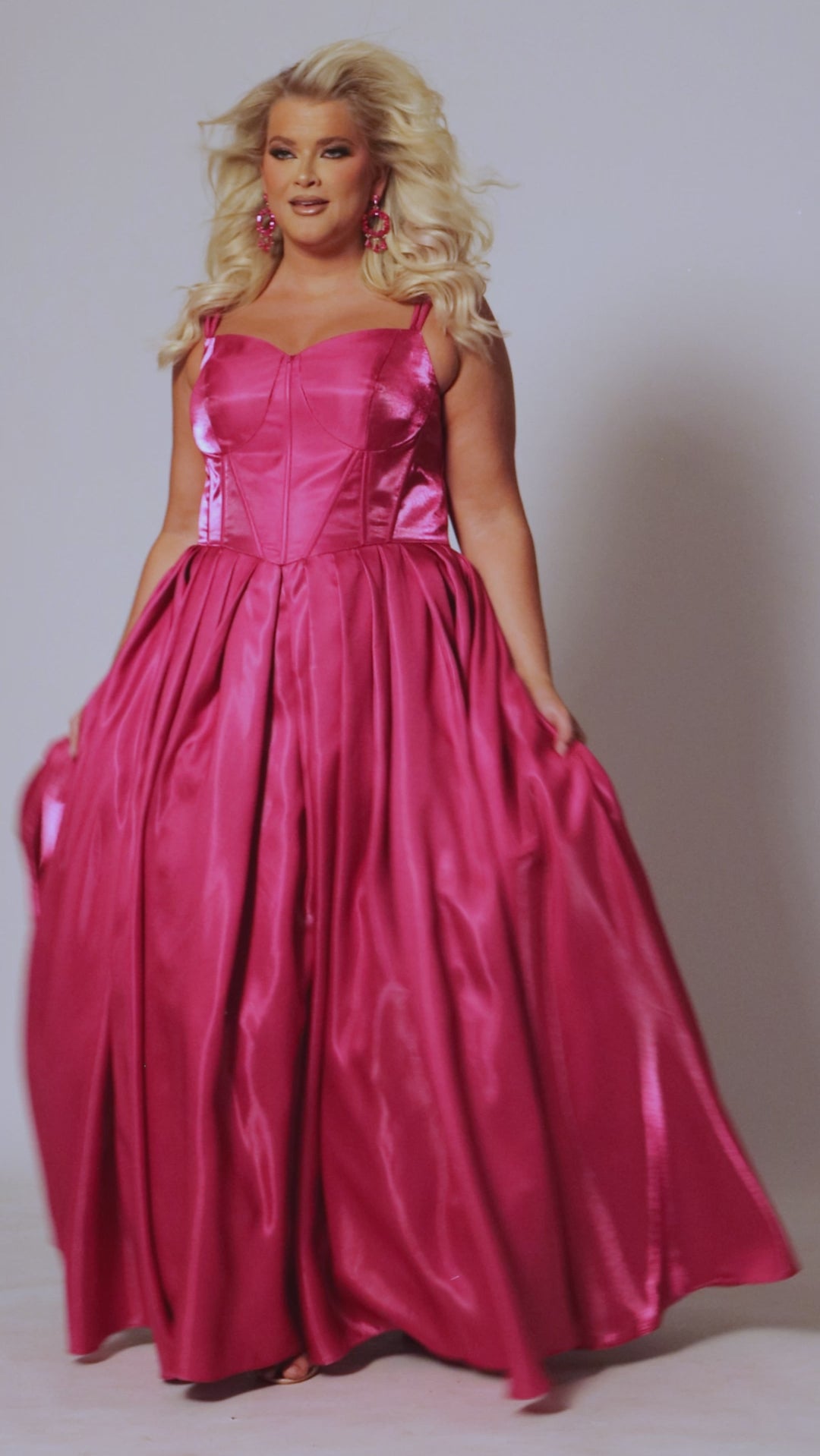 Plus size A-line prom gown with double spaghetti straps, exposed corset boning on basque waistline. Full A-line skirt with box pleats and pockets. Tease Prom style TE2518 available in berry pink or sunset orange in sizes 14-32. 