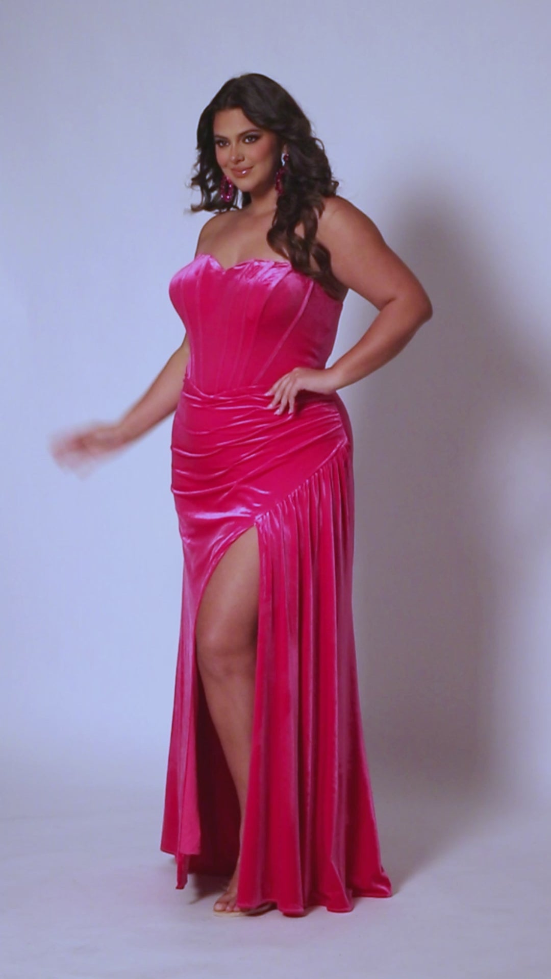 Sydney’s Closet SC7342 hot pink Barbie pink. Slim/Fitted silhouette, strapless with optional spaghetti straps. Modified Basque waist,  exposed corset boning on bodice and a ruched waist. Stretch velvet, with high slit and sweep train. 