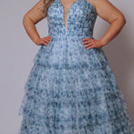 Plus size floral tiered ball gown for Prom. Tease Prom style TE2530 available in blue floral and pink floral in sizes 14-32.  Pleated deep V bodice with nude illusion mesh, natural waistline and tiered full ball gown skirt.  Spaghetti straps go into a lace up back with a modesty panel. 