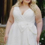 Video montage of a bride modeling a white A-line wedding gown with a V-neckline, textured fabric, and oversized waist bow, shown from multiple angles and distances. The text “Acadia” and the “Michelle Bridal” logo appear at the bottom.