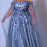 Sydney's Closet SC7379 Blue and Lilac. Detachable tulle scarves, Detachable spaghetti straps, Ball gown silhouette, Off-the-shoulder strap with elastic band, Sweetheart neckline, Full ball gown skirt, Long invisible center back zipper, Chiffon 3D flowers on glitter net over sparkle tulle, Fully lined, light satin lining