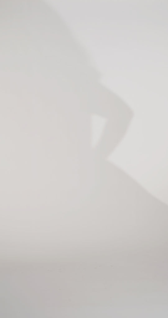 Woman models a black strapless satin ballgown with a deep V-neck and sequin and beaded detailing flowing from the bodice onto the skirt, showing the front and lace-up back before walking off screen.