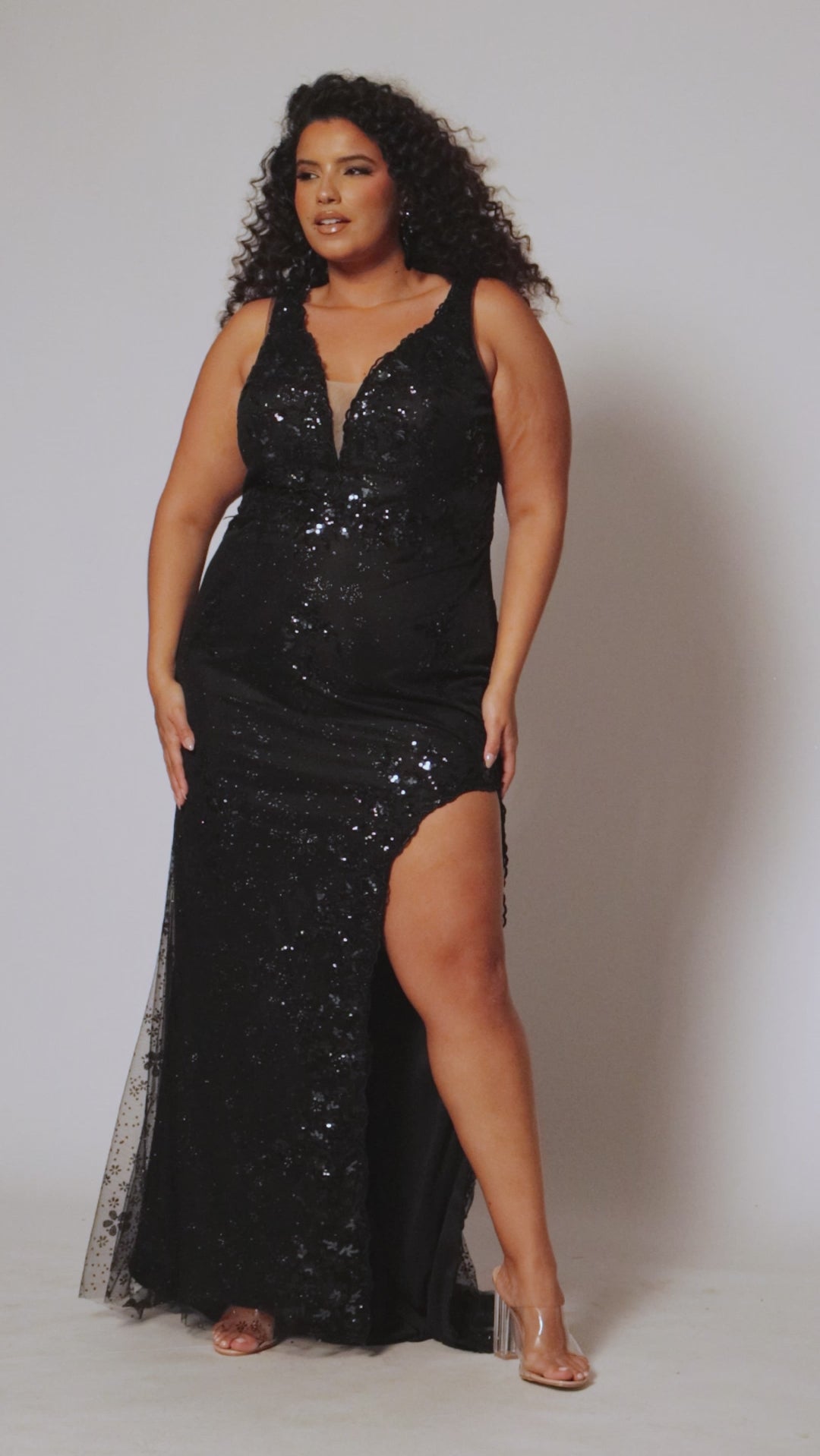 Plus size prom dress style TE2522 by Tease Prom is available in black.  Bra-friendly straps covered in glitter lace appliques with lac e trim on the deep V-neckline with nude mesh insert. Fitted skirt with high slit and lace detail on the trim of the slit. 