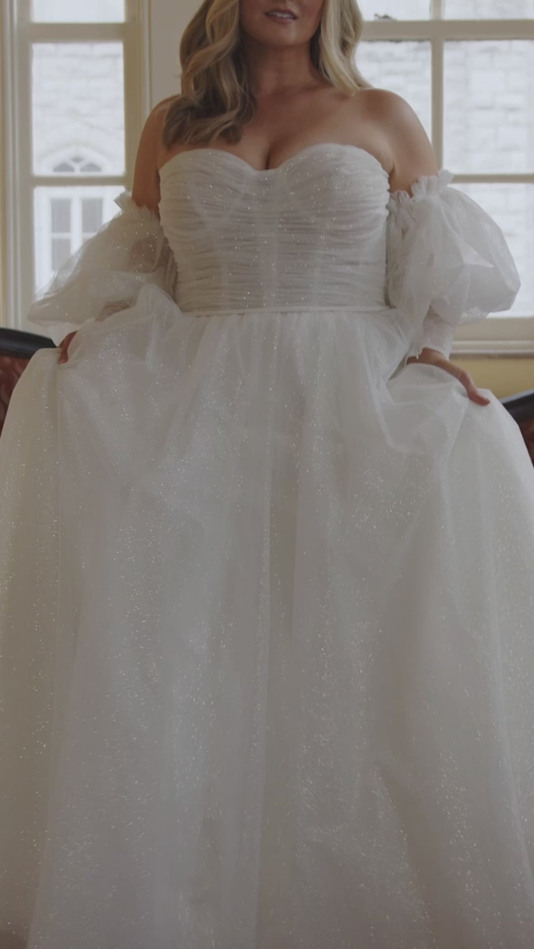 Michelle Bridal MB2422 Ivory .Soft bridal tulle, Sparkle bridal tulle, Tulle, Satin, Light stain lining, Ball gown silhouette, Strapless, Optional straps, Detachable puff sleeve with 8 inch cuff, Modified sweetheart neckline, Ruched bodice Unlined - optional lining included, Nude cups, V-back, Long invisible center back zipper, Natural waistline, Optional belt.