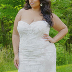 Plus-size bride modeling the MB2603 wedding gown by Michelle Bridal, showcasing a structured bodice and elegant flowing silhouette designed to flatter curves.