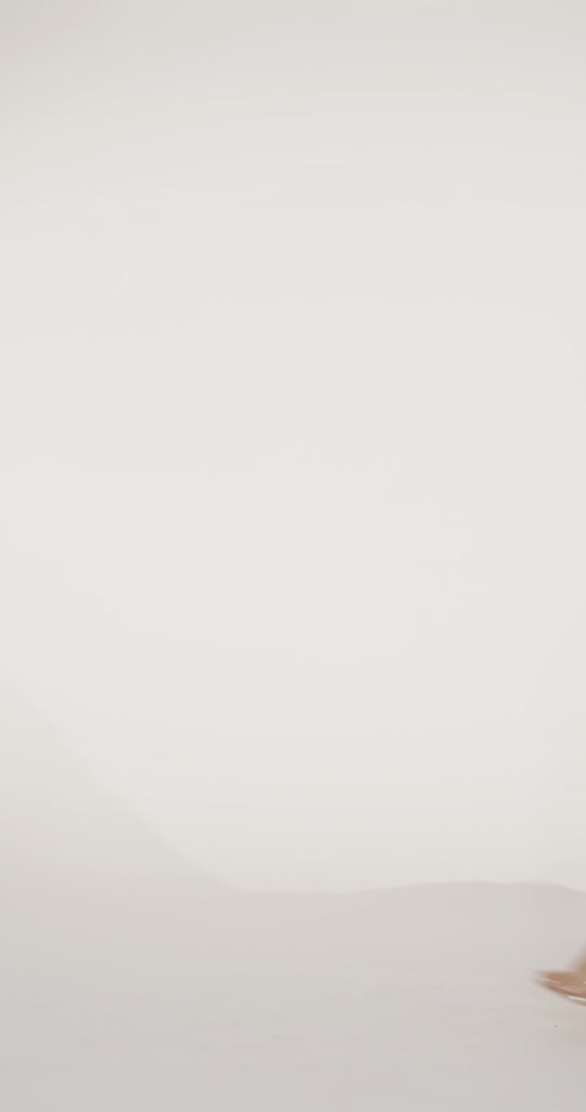 Woman models a red off-the-shoulder slim dress with a high slit, draped panel, and lace and sparkle detailing on the bodice, waving the drape panel and turning to show the lace-up back before walking off screen.