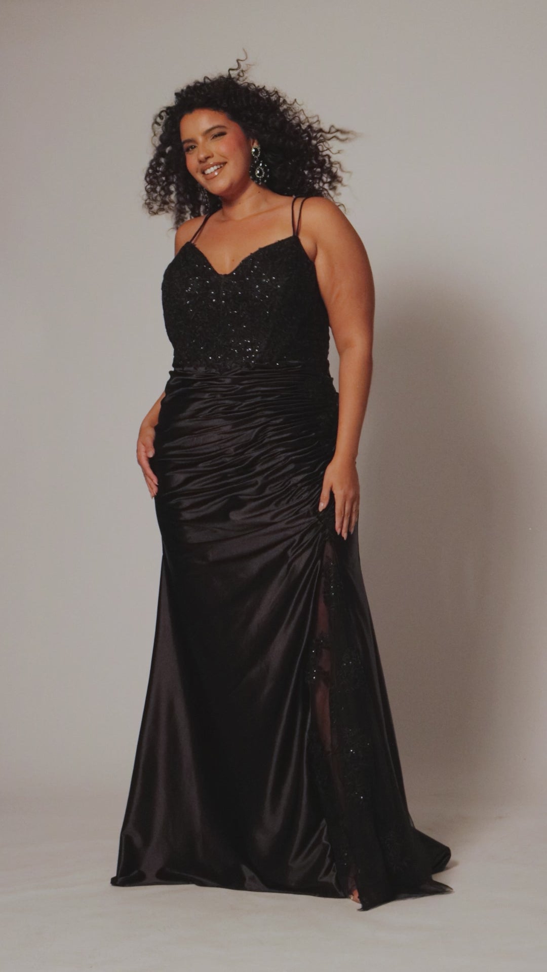 Sexy Plus Size fitted dress.  Double spaghetti straps, V-neckline covered in lace applqiues. Slim, fitted ruched skirt with slit. Slit filled in with lace. Ruched back size and tone-on-tone co vered buttons down the back. Avialable in onyx black.