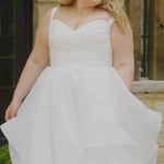 Video montage of a bride modeling a tiered white A-line wedding gown with a criss cross ruched bodice, shown outdoors from multiple angles and distances. The text “Gwendolyn” and the “Sydney's Closet” logo appear at the bottom.