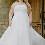 Plus-size bride wearing the Michelle Bridal MB2619 Octavia wedding gown in ivory brocade with a strapless straight neckline and tailored cuff, fitted bodice, slim A-line skirt, and grand train.