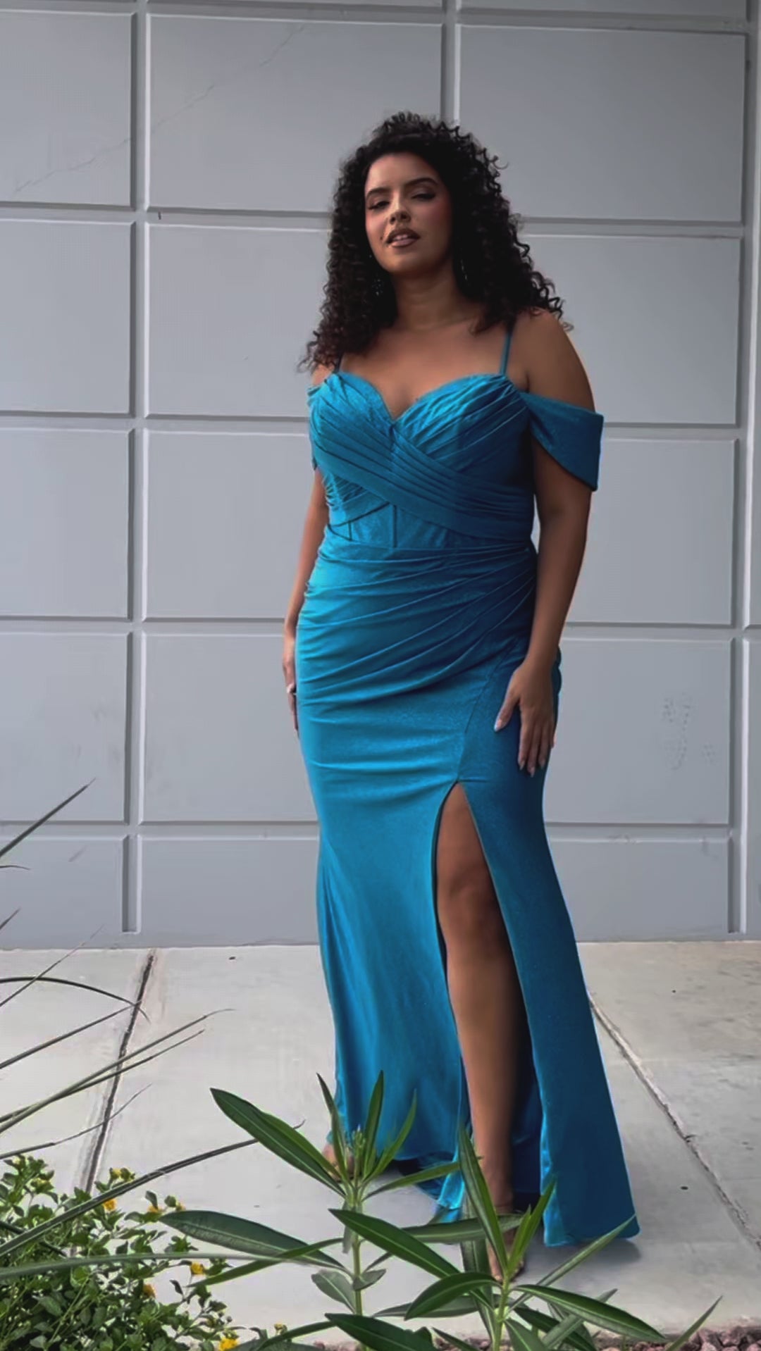 Sydney's Closet SC7402 sexy fitted prom dress in sparkle lycra .  Exposed boning on corset, drape sleeves with adjsutable spaghetti straps, high slit and ruchsed skirt. Available in violet purple, magenta pink, or turq blue and green. 