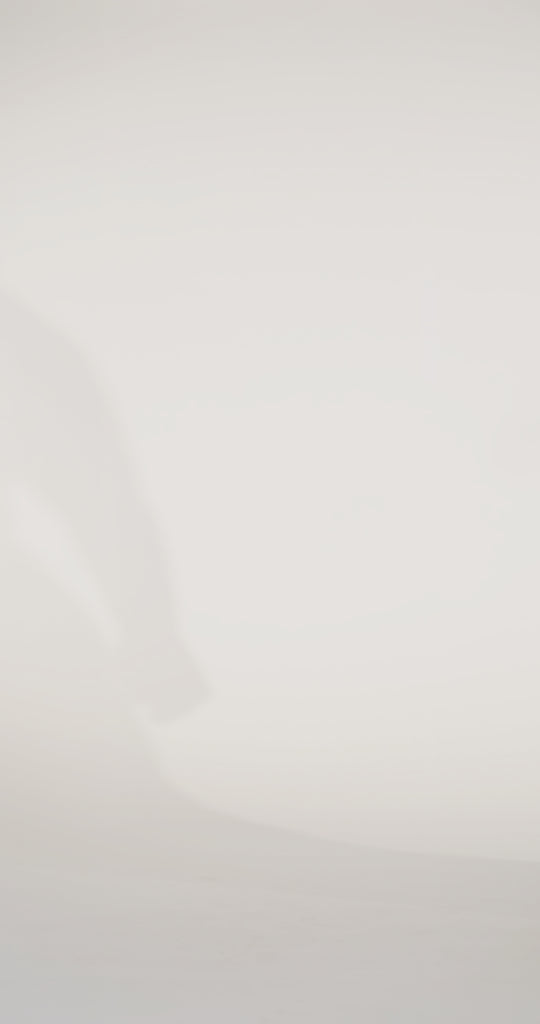 Woman models a slim black dress with a slit, exposed corset boning, a pleated band over the bust, and rhinestones along the neckline, showing the front and back before walking off screen.