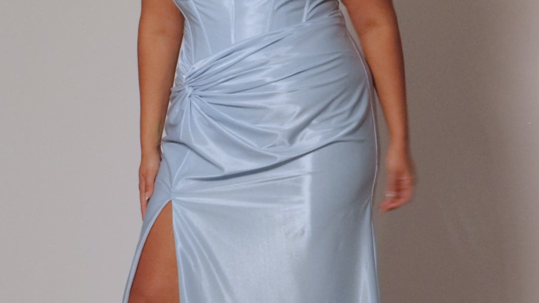 Sexy fitted pastel plus size prom dress by Tease Prom. Style TE2528. Strapless  bodice with assymetrical basque waistline. Exposed corset boning and bustier bodice is fully lined.  Ruchsing and knot detail at the waistline and high slit with sweep train on a fitted skirt.  Tease Prom style TE2528 is available in lavender purple or sky blue in plus sizes 14-24. 