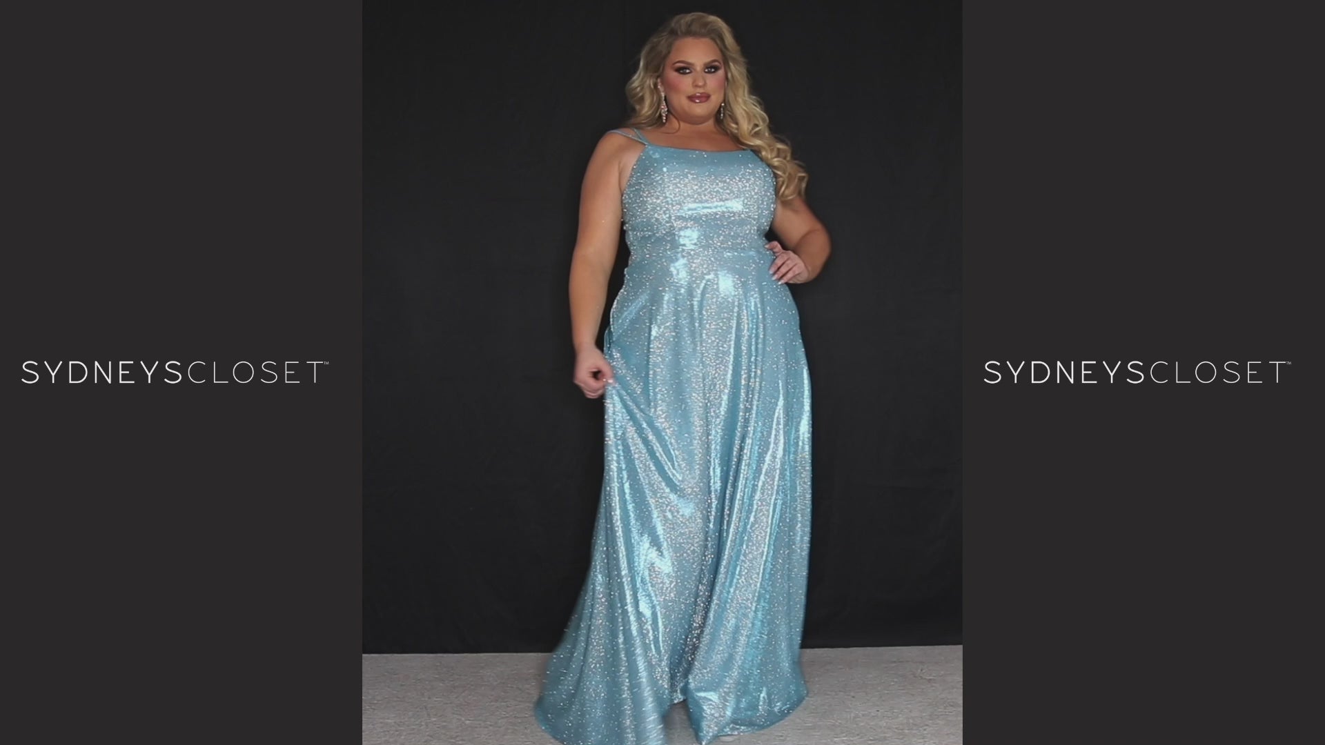 Sydney’s Closet SC7349 in purple . Full A-line silhouette with a scoop neckline and double straps. Shimmer knit offered in pink, orange, purple and aqua blue. An A-line skirt with pockets and a left leg slit. Is fully lined, has a natural waist and a long invisible zipper.