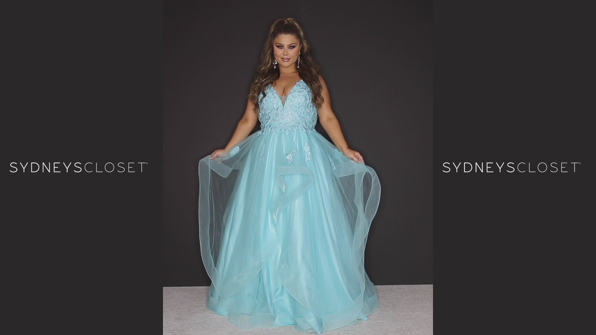 Sydney’s Closet SC7347. Tulle ballgown with lace appliques on bodice. Offered in light blue, coral, light pink and lilac purple. Has a V-neckline, bra-friendly straps and a natural waistline. A tried tulle skirt with horsehair hem. Invisible back zipper