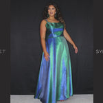 Sydney’s Closet SC7344  Shimmer satin in purple, blue and green. Full A-line silhouette, double straps and a scoop neckline. Natural waist, lace up back with modesty panel. A-line skirt with pockets and left leg slit. 