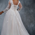 MB2010 plus size bridal gown with deep V-neckline and illusion mesh sleeves are embellished with intricate lace appliques. Full ball gown tulle skirt and lace-up back with modesty panel.