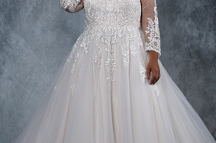 MB2010 plus size bridal gown with deep V-neckline and illusion mesh sleeves are embellished with intricate lace appliques. Full ball gown tulle skirt and lace-up back with modesty panel.