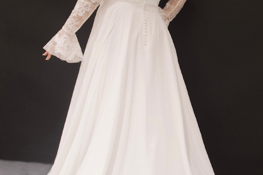Michelle Bridal plus size wedding gown.  Chiffon skirt, long train, V-neckline, long sleeves, elegant lace and detachable ruffle cuff at the wrist.  Available in ivory/nude or ivory/ivory. Only sold in stores Style MB2319.