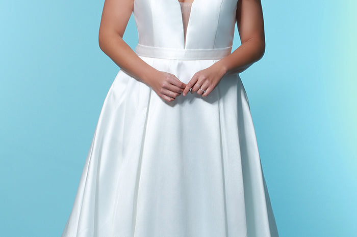 SC5229 a-line bridal gown with plunging V-neckline, bra-friendly straps, pleated skirt with pockets and a sweep train; simple satin plus size wedding gown by Sydney's Closet with pockets