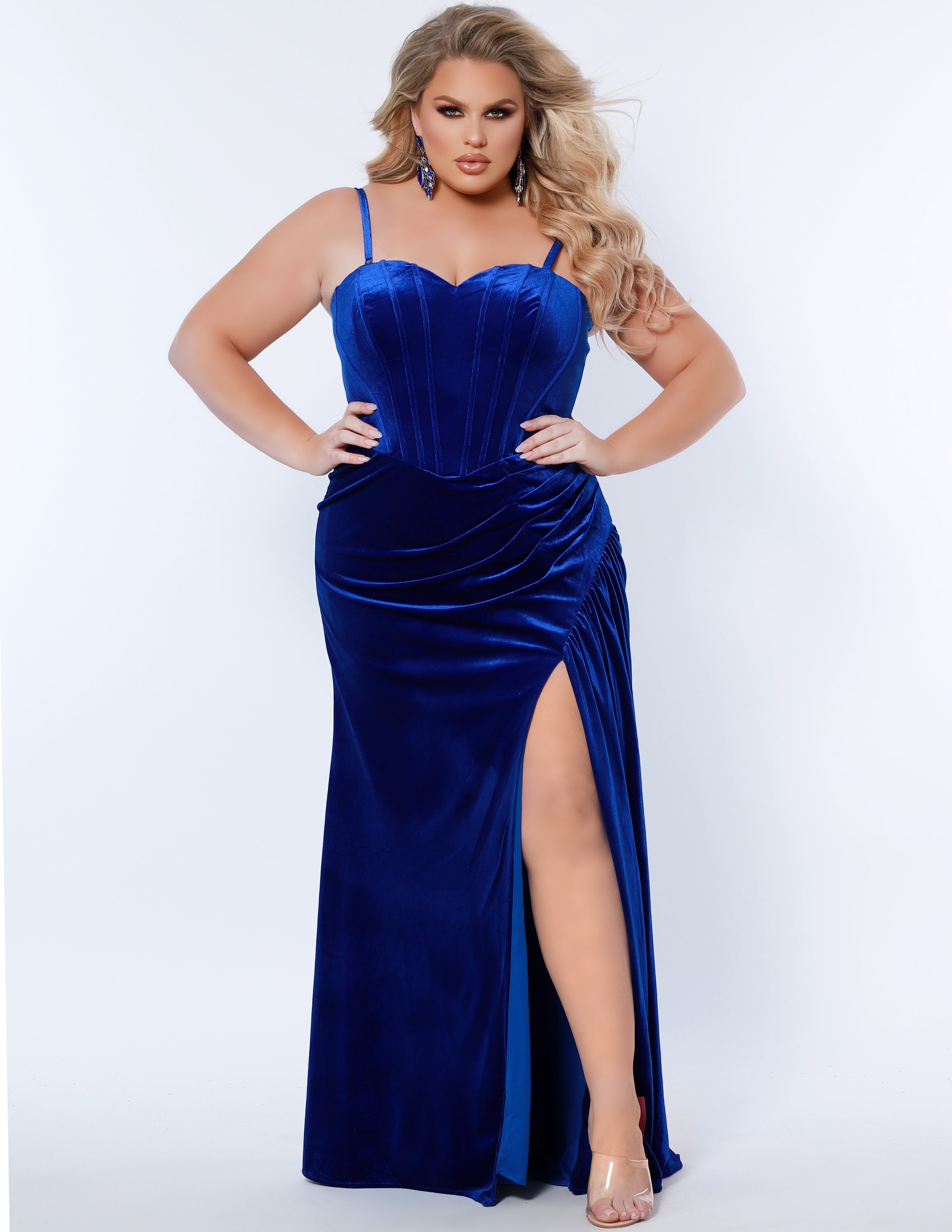 Sydney’s Closet SC7342 Royal blue. Slim/Fitted silhouette, strapless with optional spaghetti straps. Modified Basque waist, exposed corset boning on bodice and a ruched waist. Stretch velvet, with high slit and sweep train.