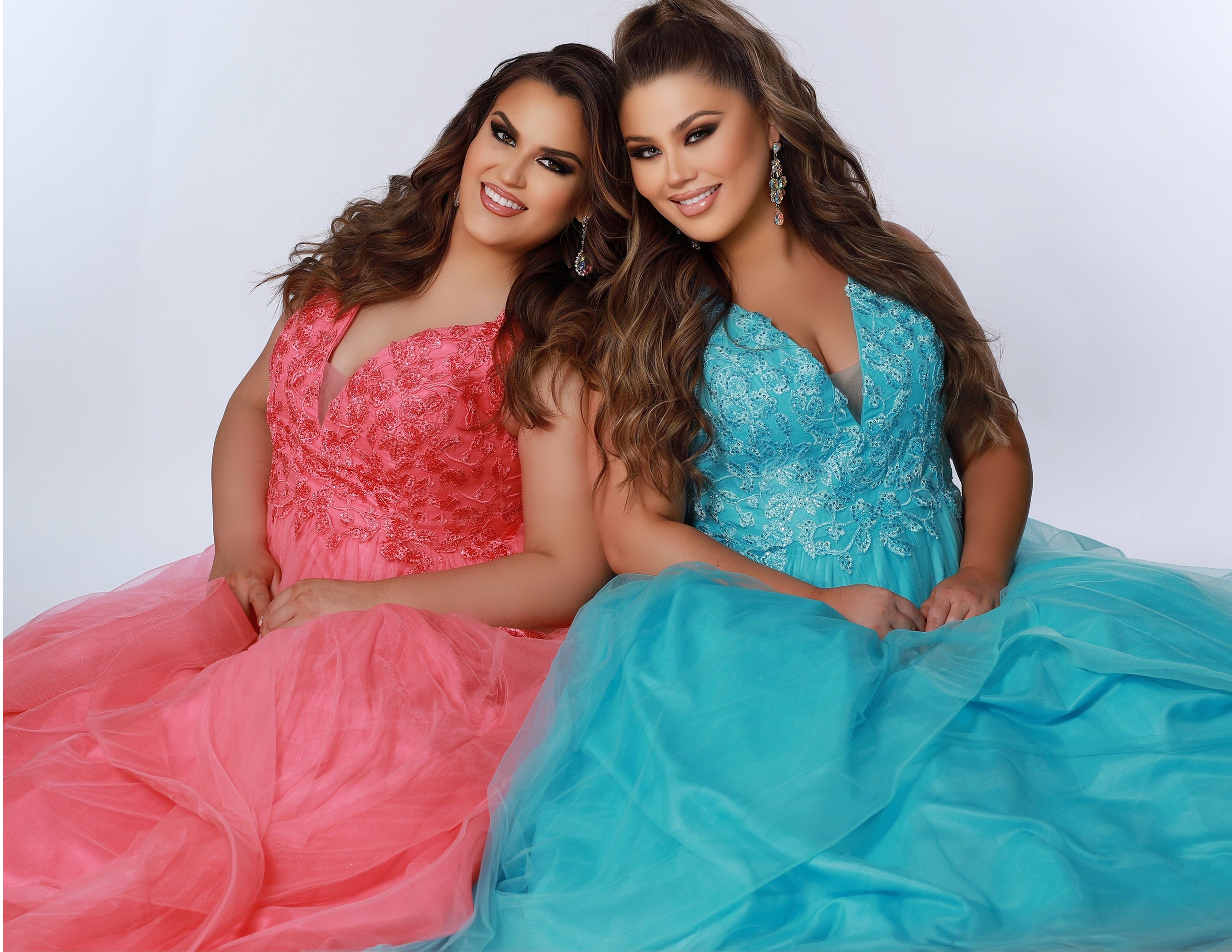 Sydney’s Closet SC7347. Tulle ballgown with lace appliques on bodice. Offered in light blue, coral, light pink and lilac purple. Has a V-neckline, bra-friendly straps and a natural waistline. A tried tulle skirt with horsehair hem. Invisible back zipper