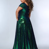 Sydney’s Closet SC7348 in peacock green. A-line silhouette with a scoop neckline and cap sleeves. Multidimensional sequins, offered in light blue, purple and peacock green. Has a natural waistline, A-line skirt with pockets, and a horsehair hem. 