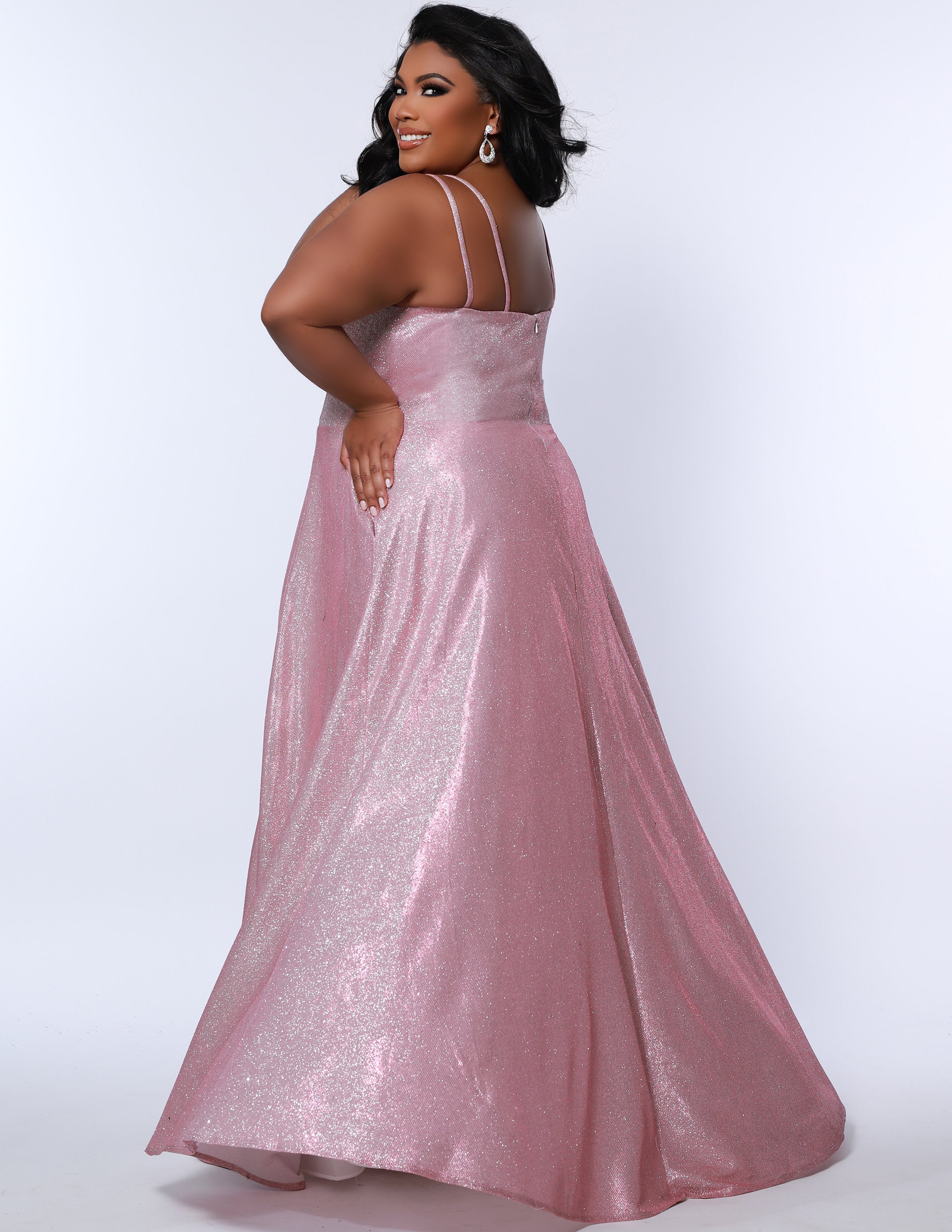 Sydney’s Closet SC7349 in pink. Full A-line silhouette with a scoop neckline and double straps. Shimmer knit offered in pink, orange, purple and aqua blue. An A-line skirt with pockets and a left leg slit. Is fully lined, has a natural waist and a long invisible zipper.
