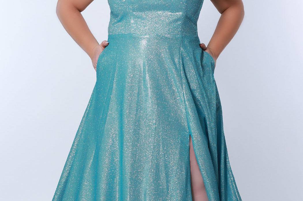 Sydney’s Closet SC7349 in aqua blue . Full A-line silhouette with a scoop neckline and double straps. Shimmer knit offered in pink, orange, purple and aqua blue. An A-line skirt with pockets and a left leg slit. Is fully lined, has a natural waist and a long invisible zipper.