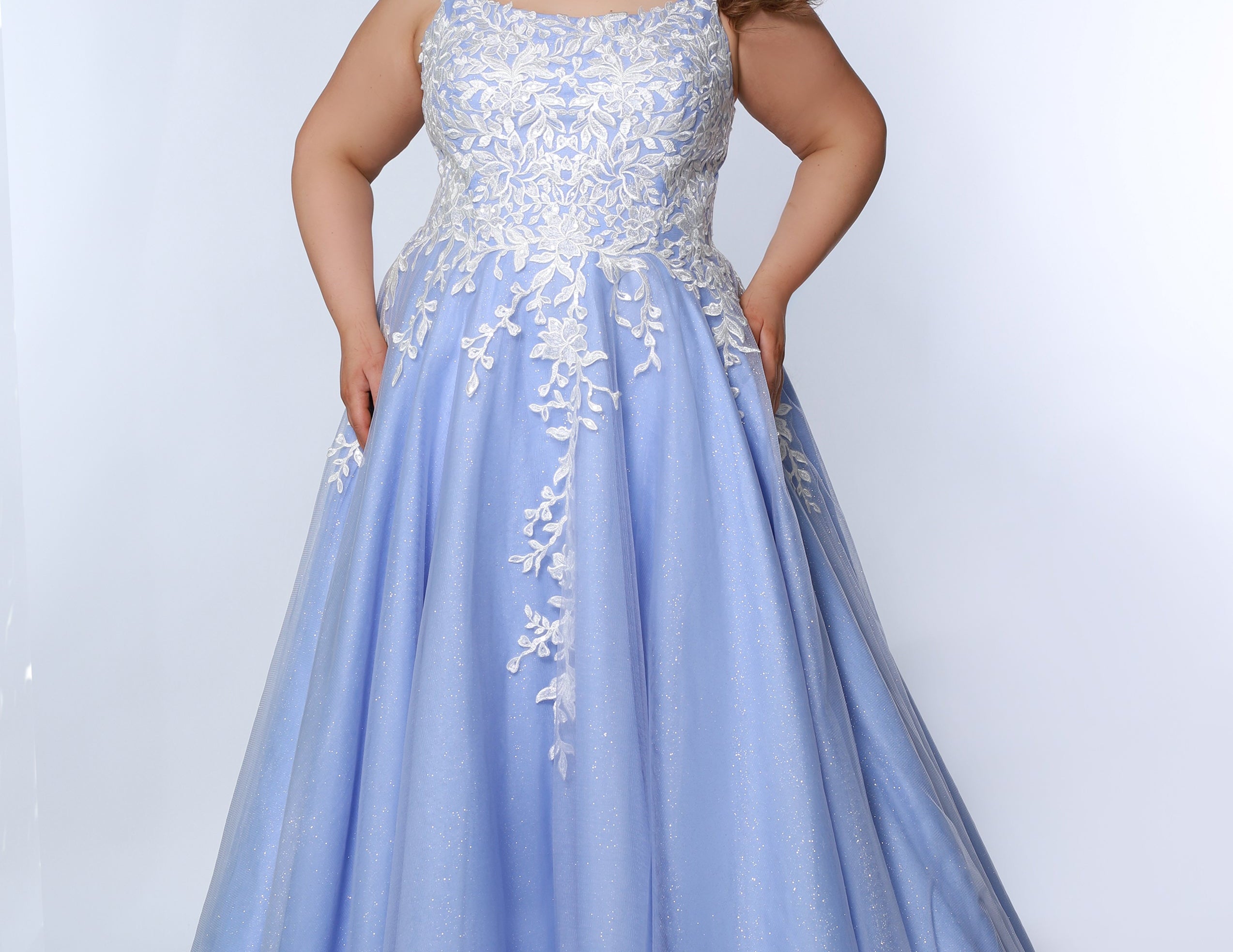 Sydney’s Closet SC7350 in periwinkle. Full A-line silhouette with a scoop neckline and lace covered straps. Beaded and appliqued, with 3D flowers on the bodice. A natural waistline and stretch knit lining. Has a floor length tulle skirt and a long invisible back zipper. 