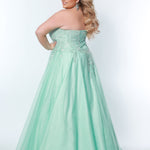 Sydney’s Closet SC7352 in mint green. Full A-line silhouette with a halter neckline, a natural waistline, and an A-line skirt with crinoline, tulle and glitter tulle. Lace appliques cover the partially lined bodice and top of the skirt. Has a lace up back and modesty panel. Offered in  Ivory, Mint, Mocha, Orchid, and Peach.