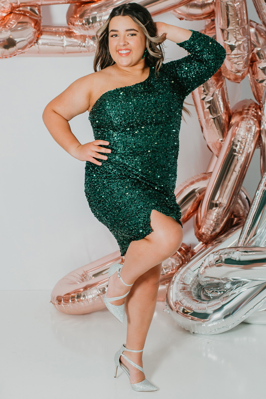This is SC8112 in our Sydney's Closet Homecoming collection. This plus size party dress comes in green, black, white, red, and blue! This dress has one shoulder long sleeve, natural waistline, and a scoop neckline. This fitted all over sequin dress has a small slit above the right knee! This gown is set in stone for this homecoming season!