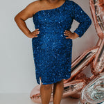 Plus size short sequin party dress with one-shoulder long sleeve, slit and center back zipper. Fabulous jewel tone colors: Hunter Green, Onyx Black, Ruby Red, Pearlescent White or Sapphire Blue. Style SC8112 by Sydney's Closet