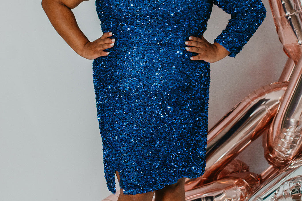 Plus size short sequin party dress with one-shoulder long sleeve, slit and center back zipper. Fabulous jewel tone colors: Hunter Green, Onyx Black, Ruby Red, Pearlescent White or Sapphire Blue. Style SC8112 by Sydney's Closet