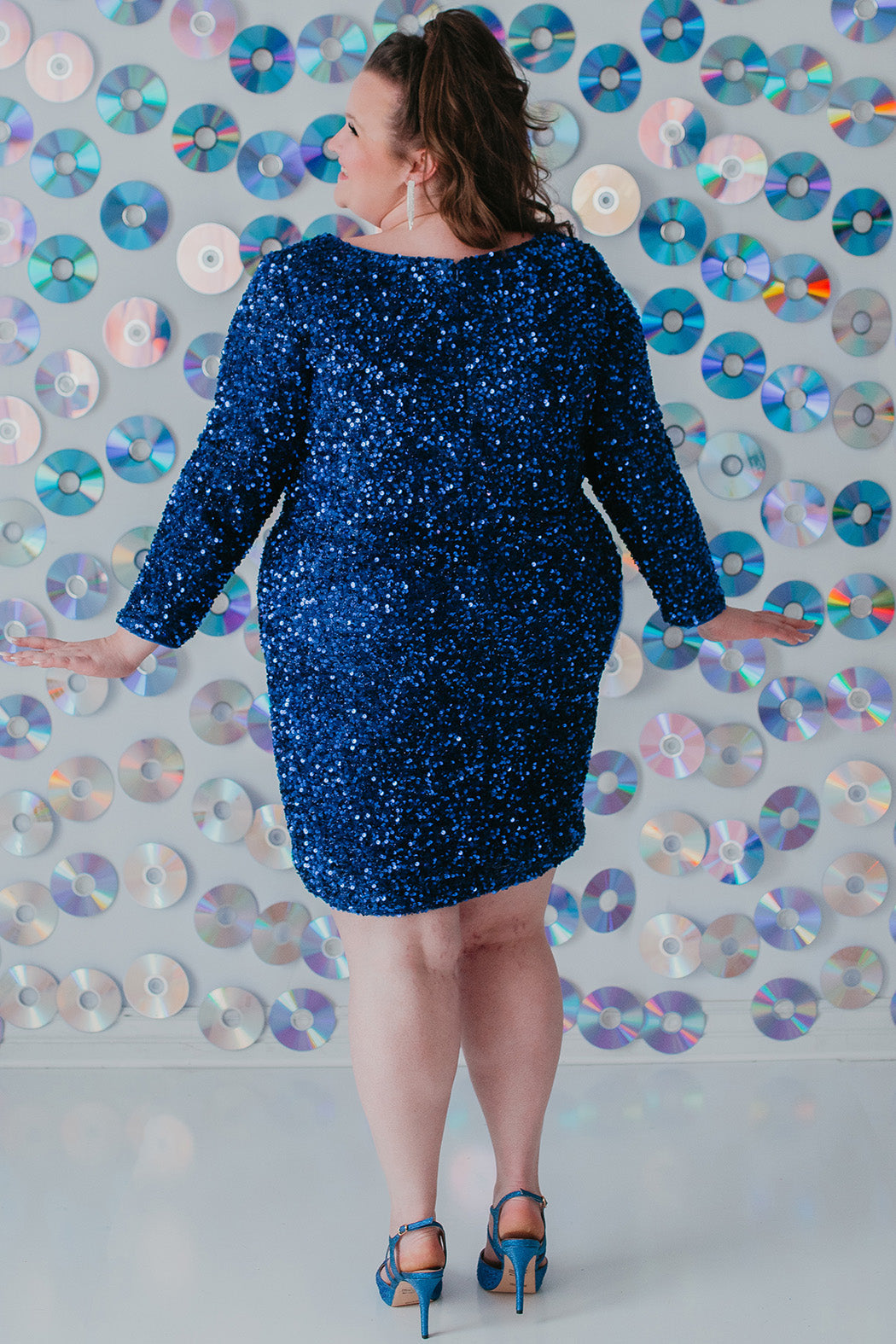 Sydney's Closet Style SC8113 plus size sequin party dress with long sleeves, scoop nekcline and slit. Available in blue, red, black and forest green.