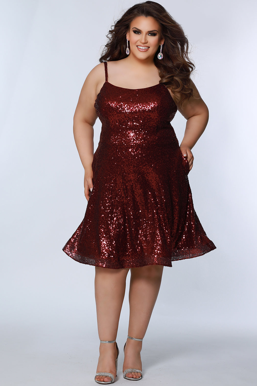 This is SC8122 in our Sydney's Closet Homecoming collection. This plus size party dress comes in white, red, blue, light blue, green, and purple! This dress has straps covered in sequins, a scoop neckline, and a natural waistline. This a-line all over sequins dress has a horsehair hem so that you can dance the night away! To make it even more spectacular, we have added pockets to make this the perfect dress for homecoming season!