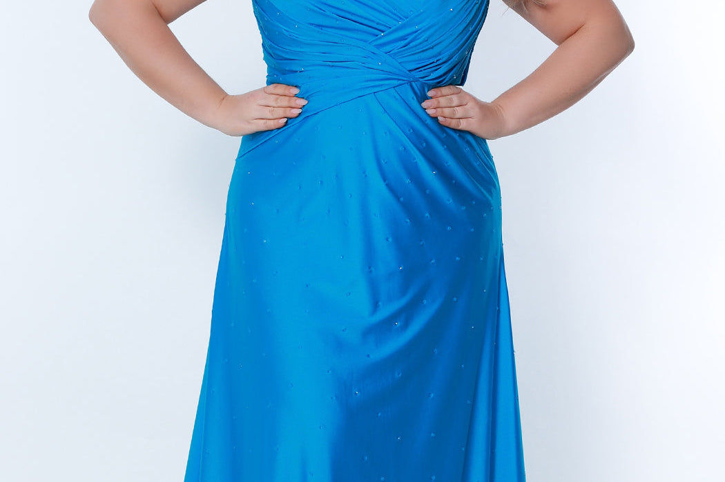 Tease Prom TE2318 electric blue. Fit and Flare silhouette with a natural waistline and fitted skirt. V-neckline and V-bodice with pleats. Stretch lycra with hot fix stones. Sleeveless, bra-friendly straps, sweep train and a center back zipper. 