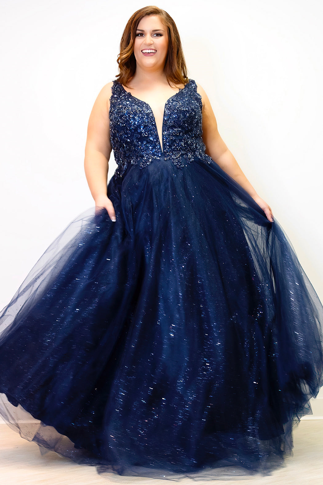 Tease Prom TE2323 Navy Blue. Ballgown silhouette with a full A-line tulle skirt. Natural waistline and a sweetheart neckline and bra-friendly straps. Heavily beaded bodice with tone-on-tone beading on lace appliques. Embroidered lace and sparkle tulle skirt with pockets. Lace-up back with modesty panel.