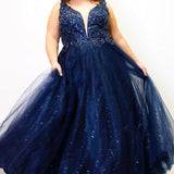 Tease Prom TE2323 Navy Blue. Ballgown silhouette with a full A-line tulle skirt. Natural waistline and a sweetheart neckline and bra-friendly straps. Heavily beaded bodice with tone-on-tone beading on lace appliques. Embroidered lace and sparkle tulle skirt with pockets. Lace-up back with modesty panel. 